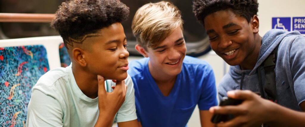 Three students looking at a mobile phone.