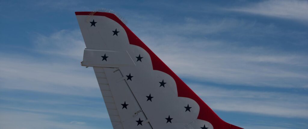 Tail of an airplane with blue stars and a red pattern.