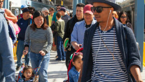 Passengers on platform including mother with stroller.